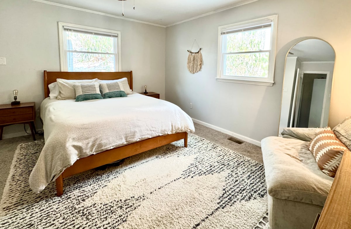 宽敞的主卧室，配有柔软舒适的标准双人床、工作区和两个衣柜。 