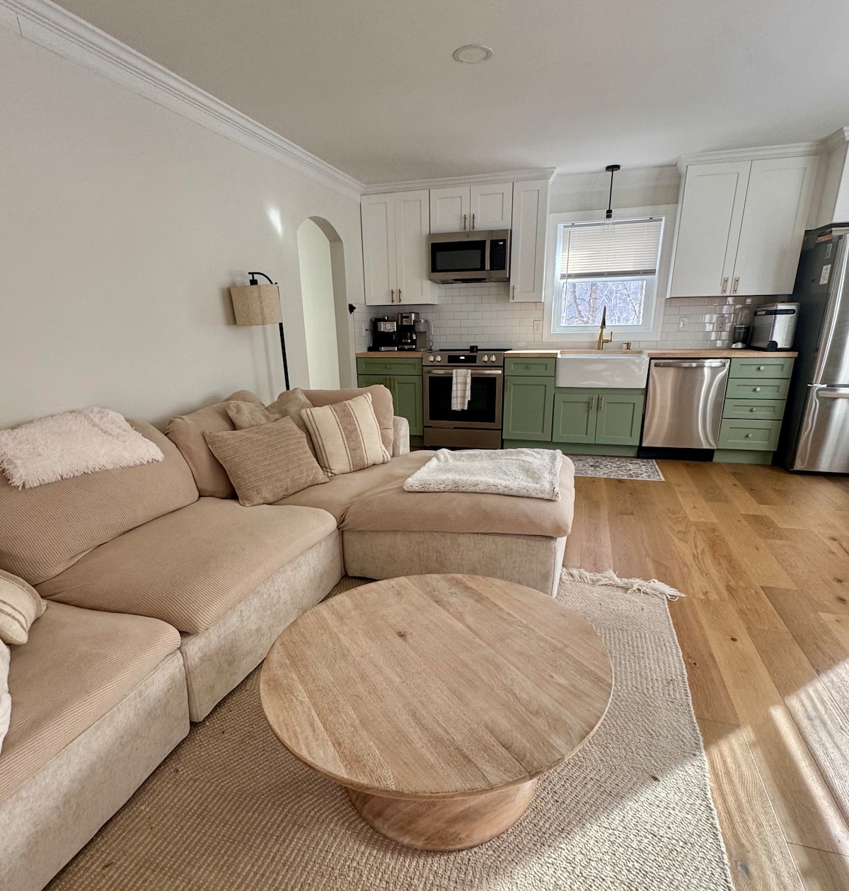 明亮舒适的客厅，配有燃气壁炉、开放式厨房和舒适的超大沙发。