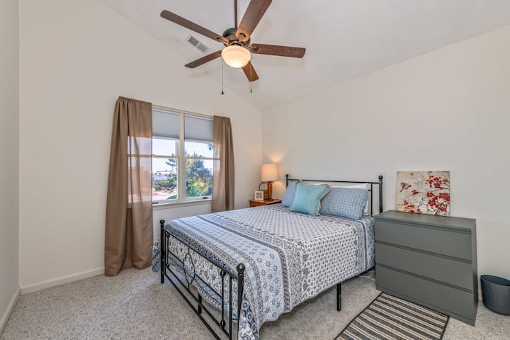 Bedroom with ceiling fan, dresser and closet. Vaulted ceiling.