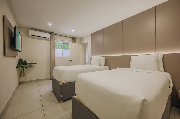 Dormitorio 7: una cómoda habitación con dos camas individuales, sábanas limpias y una sensación limpia y moderna, ideal para compartir y dormir bien.