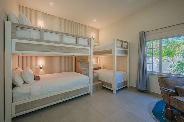 Dormitorio 2: una habitación luminosa y cómoda con una litera doble y una litera tamaño queen, perfecta para que las familias o los niños compartan y disfruten de una buena noche de sueño.