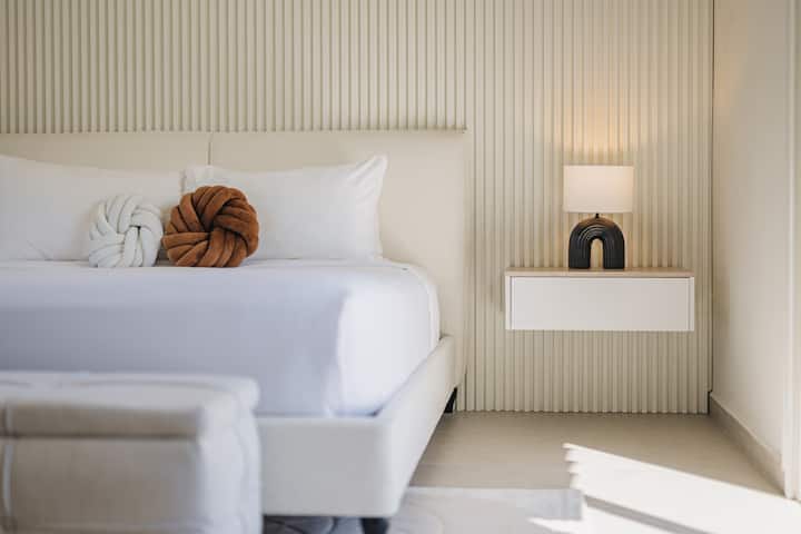 Dormitorio 3: una habitación acogedora y relajante con una cama tamaño king, sábanas frescas e iluminación suave, perfecta para una noche de sueño cómoda y reparadora.