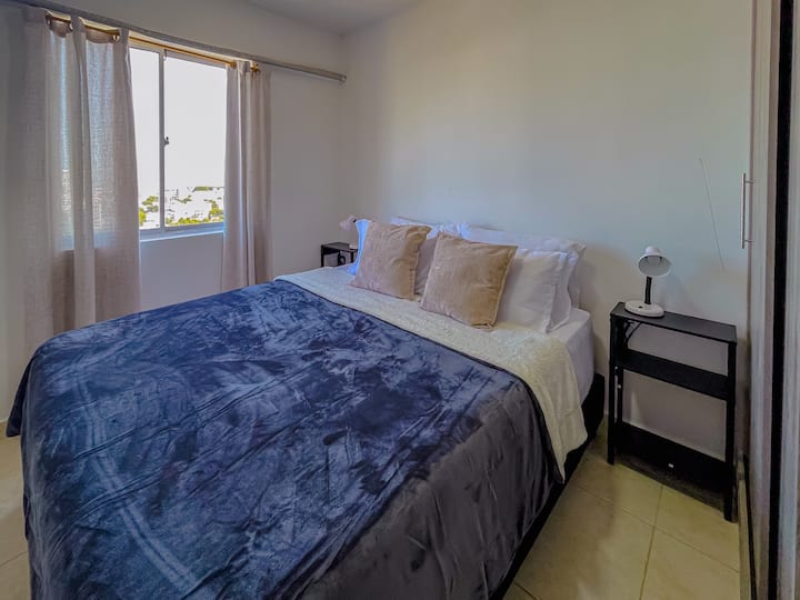 استمتع بالرحابة التي يوفرها السرير بحجم كوين والمروحة عالية الطاقة، بالإضافة إلى خزانة ملابس كبيرة مقسمة، مما يجعلها مثالية للإقامات الطويلة.