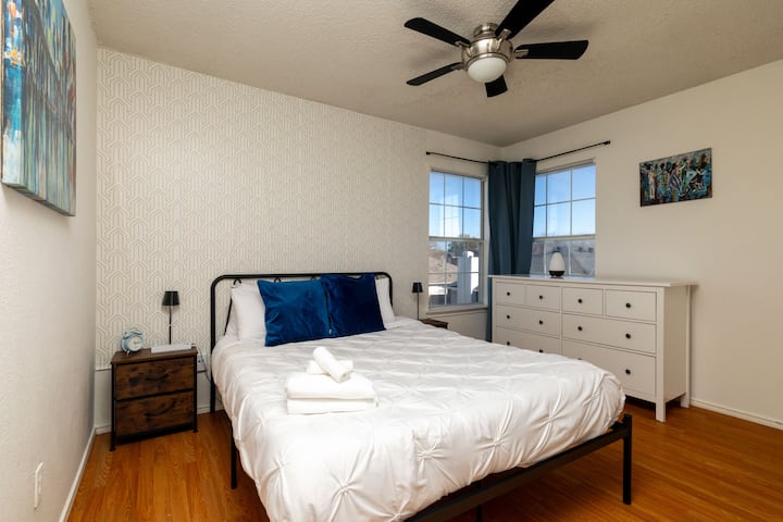 Stylish second bedroom with a queen bed and modern industrial touches.