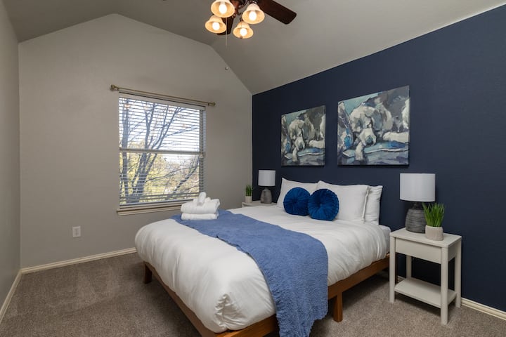 Elegant fourth bedroom with a queen bed and navy accent wall.