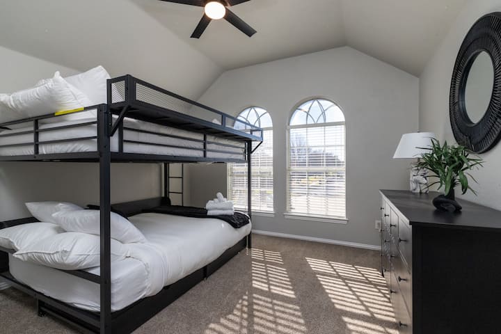 Fun, spacious bedroom with industrial-style bunk beds and vaulted ceilings.