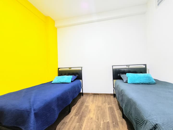 Recámara con dos camas cómodas, ideal para familias o amigos que comparten el espacio.