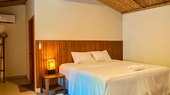Spacious suite, with carpet at the foot of the bed, premium pillows and sheets, night table with night lamp, 55-inch Smart TV and private bathroom. It has a baby crib and a play mat.