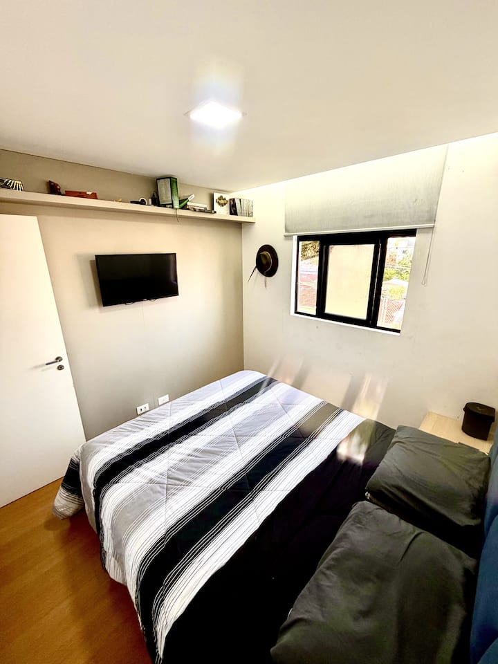 Chumba chenye starehe kilicho na kitanda aina ya queen, Smart TV na mwangaza bora, bora kwa ajili ya kupumzika na kuongeza nguvu baada ya siku ya kutembelea mandhari au kufanya kazi.