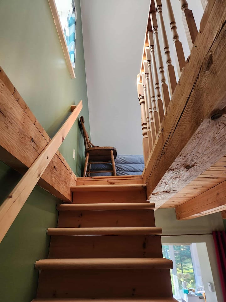 Escalier menant à la mezzanine, où se trouve la chambre et ses deux lits