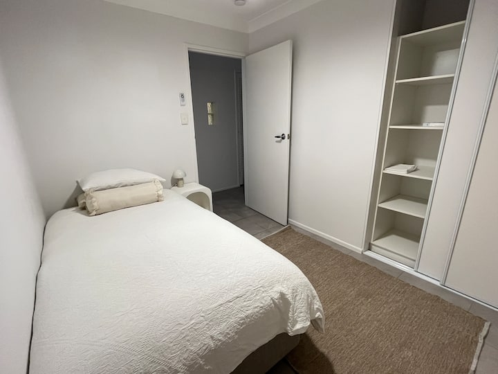 เตียงเดี่ยวคิงไซส์ผ้าม่านสีเข้มในห้องพัดลมเพดานตู้เสื้อผ้าพร้อมที่เก็บเสื้อผ้ามากมาย