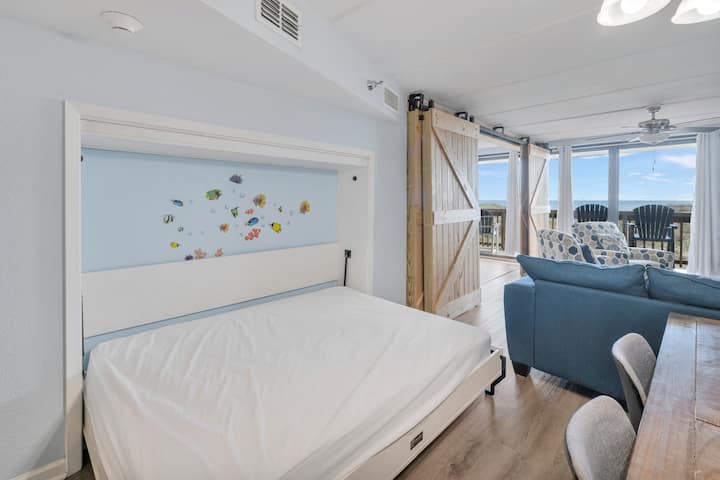 Réveillez-vous au son de la brise marine dans votre studio côtier doté d'un lit escamotable et de charmantes portes de grange qui s'ouvrent sur votre balcon privé.