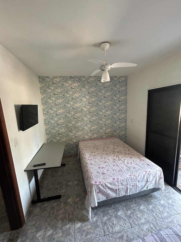 Dormitorio 1, con una cama doble y una cama individual, ventilador de techo y acceso al balcón.