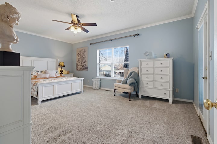 Deze ruime, lichte slaapkamer biedt een rustgevend toevluchtsoord met een comfortabel bed, pluche tapijt en zachtblauwe muren. Doordacht ingericht met een dressoir, nachtkastjes en gezellige zitjes, het is perfect voor rust en ontspanning. 