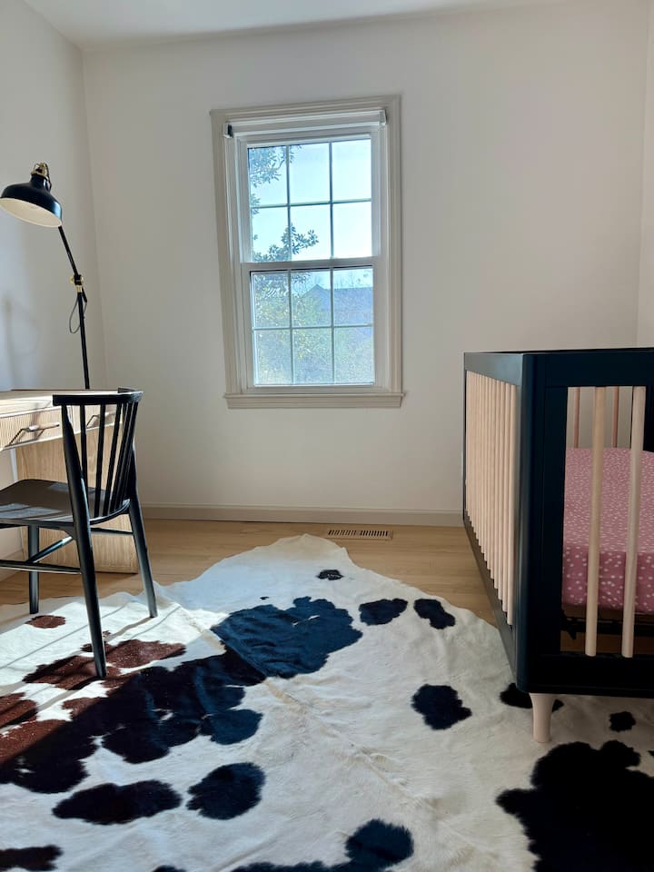 第三间客房配有一张全尺寸婴儿床、衣橱和书桌