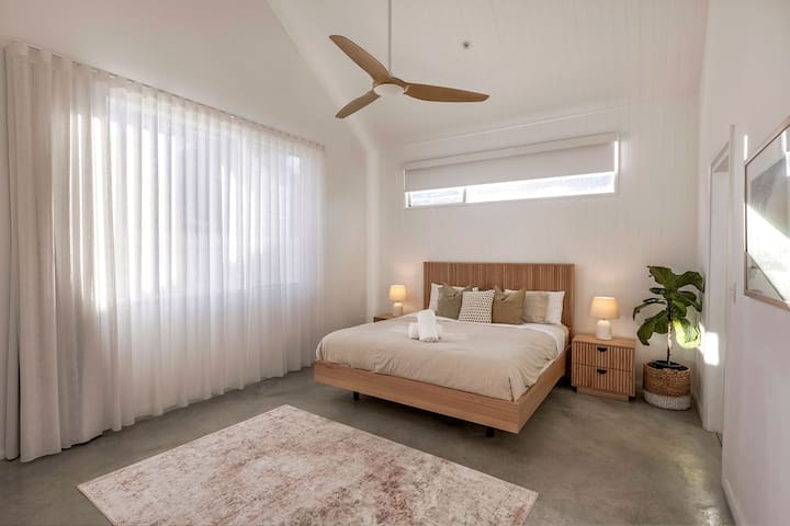 Posteľ veľkosti King, veľký stropný ventilátor, zatemňovacie a priesvitné záclony.