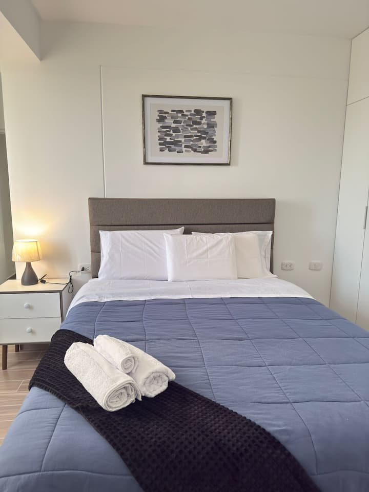Grande chambre double avec lit Queen size, matelas de luxe et linge de lit en coton Pima 300 fils.