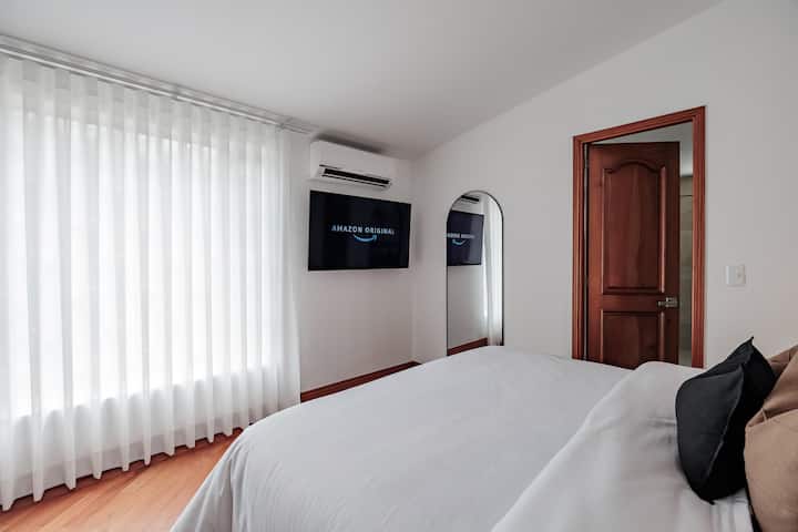 Suite privada n.º 3: dormitorio con cama tamaño queen, Smart TV, aire acondicionado, espejo de cuerpo entero y acceso directo a un baño privado en la habitación.

