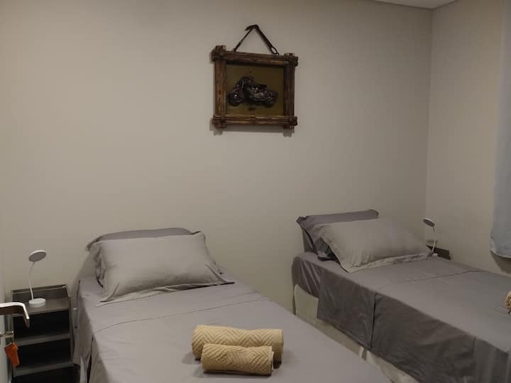 На приземјето, спална соба со 2 единечни кревета кои може да се спојат во еден брачен кревет со помош на прекривка. Душеци со густина 33. Дополнителни перници за поголема удобност, клима-уред, странични масички и светилки. Мебел за организирање облека.