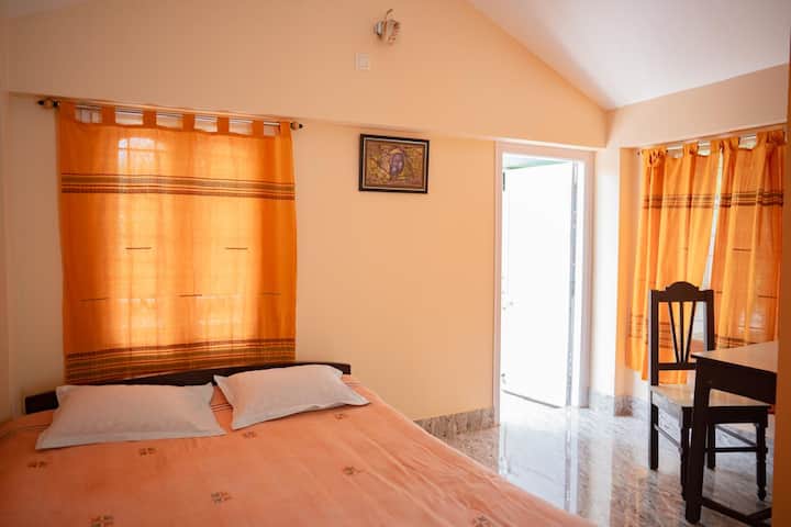 Amplio dormitorio con aire acondicionado y balcón privado, ideal para dos huéspedes. La habitación incluye un baño adjunto, almirah, área de estudio y todas las comodidades básicas para una estadía cómoda.