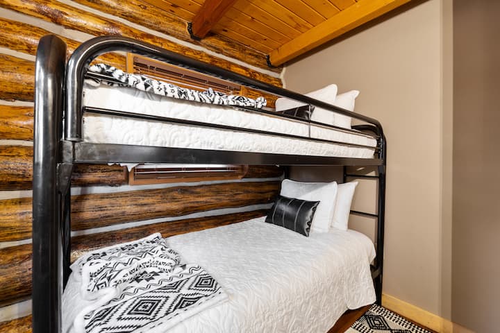 Twin-over-full stapelbed met schoon beddengoed, perfect voor kinderen of extra gasten.