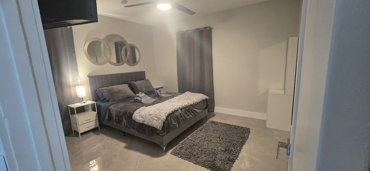 Dormitorio privado y moderno con una cómoda cama tamaño queen, sábanas frescas, televisor inteligente y espacio en el armario. Baño exclusivo para los huéspedes. Tranquilo, limpio y diseñado para una estadía relajante.