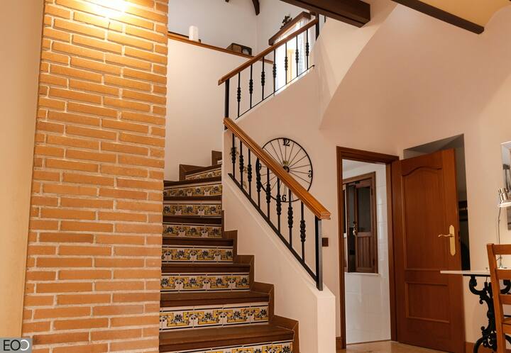 Escalera de azulejos con barandilla de forja: mucho encanto rústico en el interior de la villa.