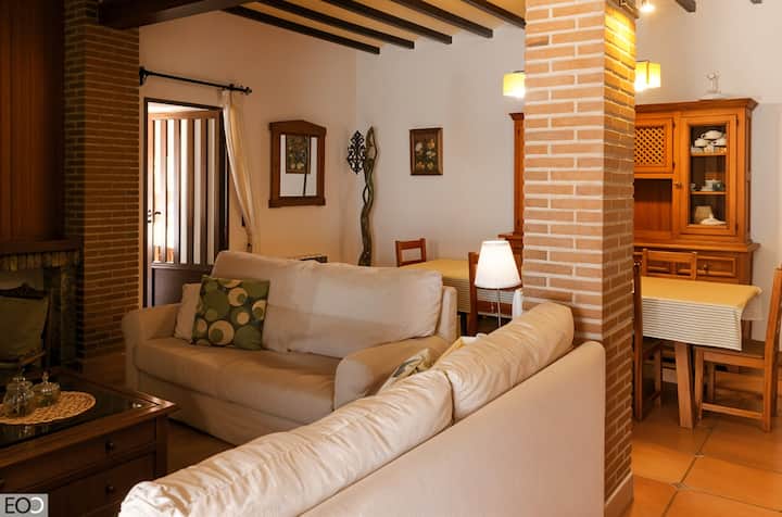 Zona de estar con sofá, aparador y buena luz natural: rincón acogedor para relajarse.