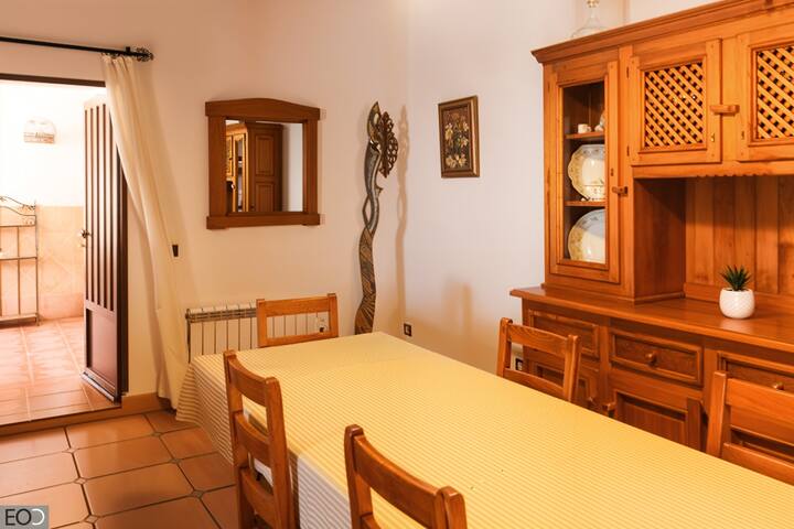 Comedor 1 con mesa, espejo y mueble de madera junto a la escalera: acogedor y luminoso.