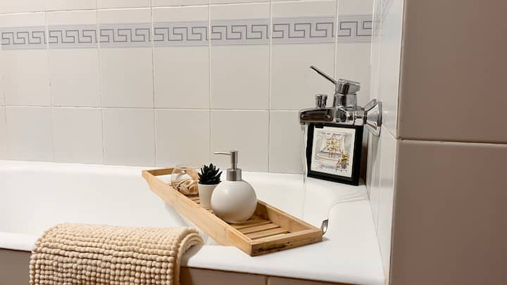 Detalle de la bañera del baño 2 con bandeja de madera y toalla: un rincón de relax.
