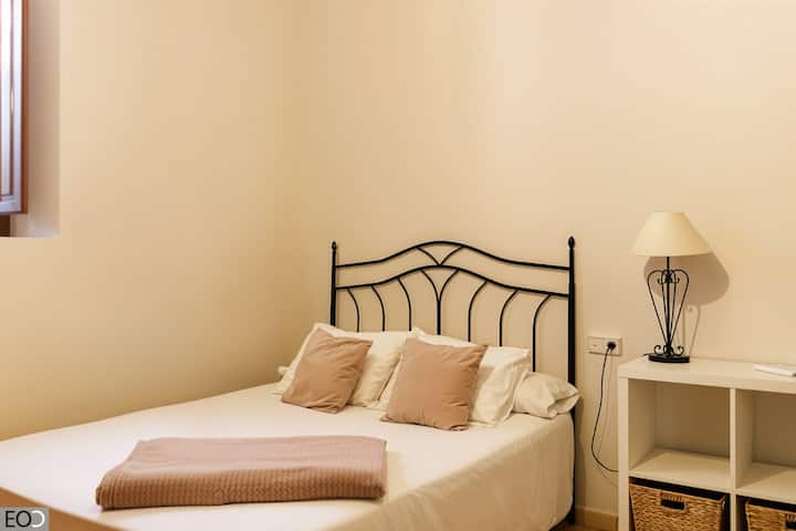 Dormitorio 2 con cama de matrimonio, cabecero de forja y mesilla: acogedor y luminoso.