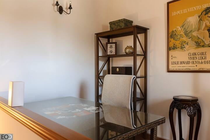 Rincón de estudio con estantería, silla y decoración de cine: cómodo para trabajar o leer.