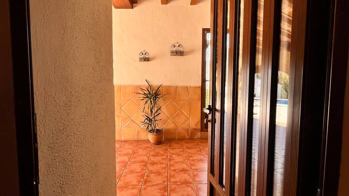 Rincón con planta junto al paso entre estancias: detalles que dan calidez a la villa.