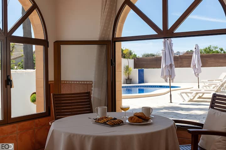 Zona de comedor junto al ventanal con vistas a la piscina: luz y paisaje en cada comida.