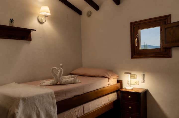 Dormitorio 4 con cama individual, mesilla y espejo con vistas: acogedor y luminoso.