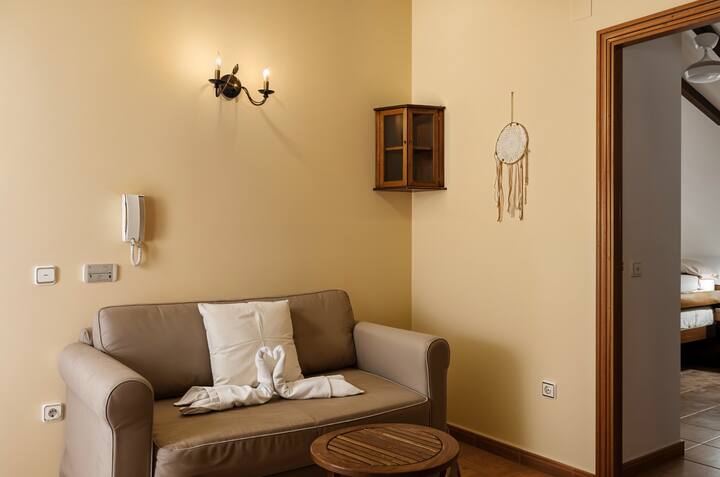 Salita con sofá y teléfono junto al dormitorio: un rincón cómodo y luminoso.