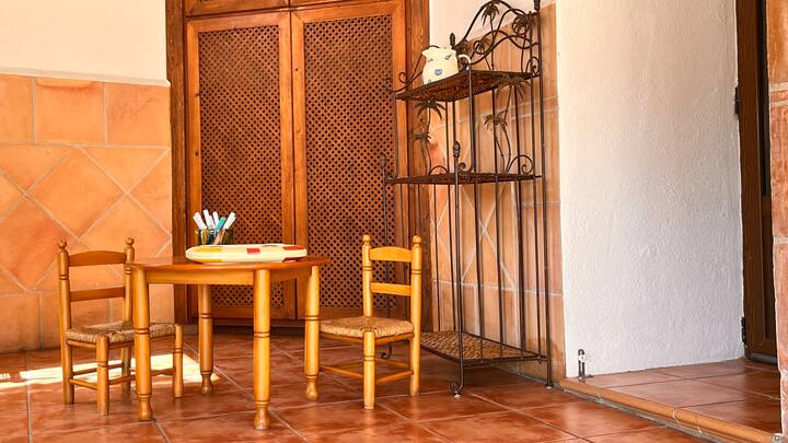 Mesa y sillas infantiles junto a la reja de forja: un espacio pensado también para los peques.