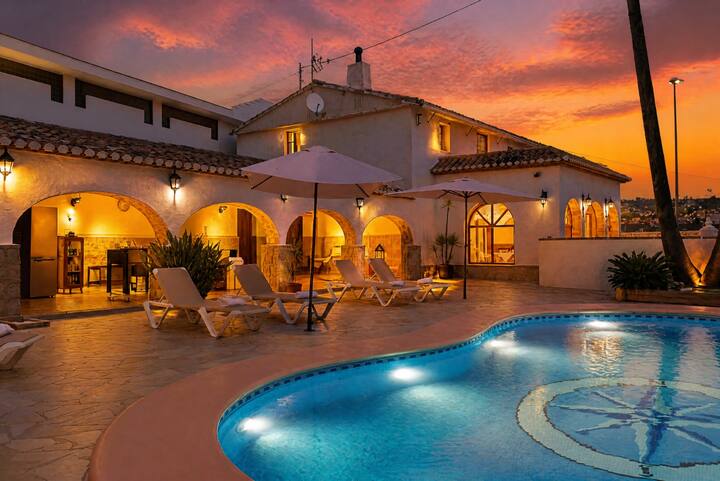 Piscina y terraza de la villa bajo un cielo de atardecer: el broche perfecto al día.