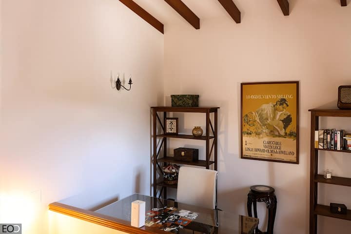Zona para trabajar con escritorio de cristal y estanterías: ambiente tranquilo y luminoso.