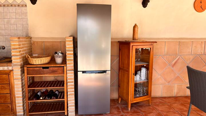 Cocina 2 con botellero, nevera y vitrina de madera: mucho espacio de almacenaje.