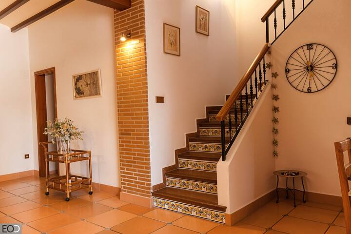Recibidor con escalera de azulejos y detalles decorativos: bienvenida con encanto tradicional.