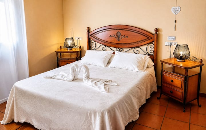 Dormitorio 3 con cama de matrimonio, cabecero de madera y mesillas: cálido y muy acogedor.