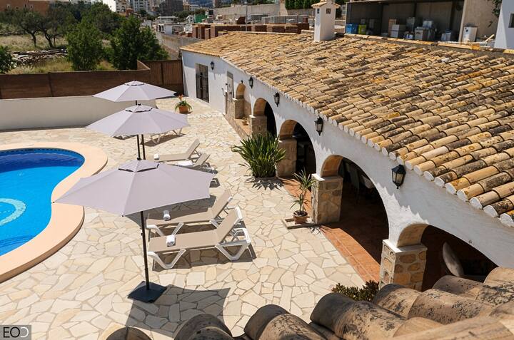 Vista aérea del patio con piscina, sombrillas y tumbonas: gran zona exterior para disfrutar.