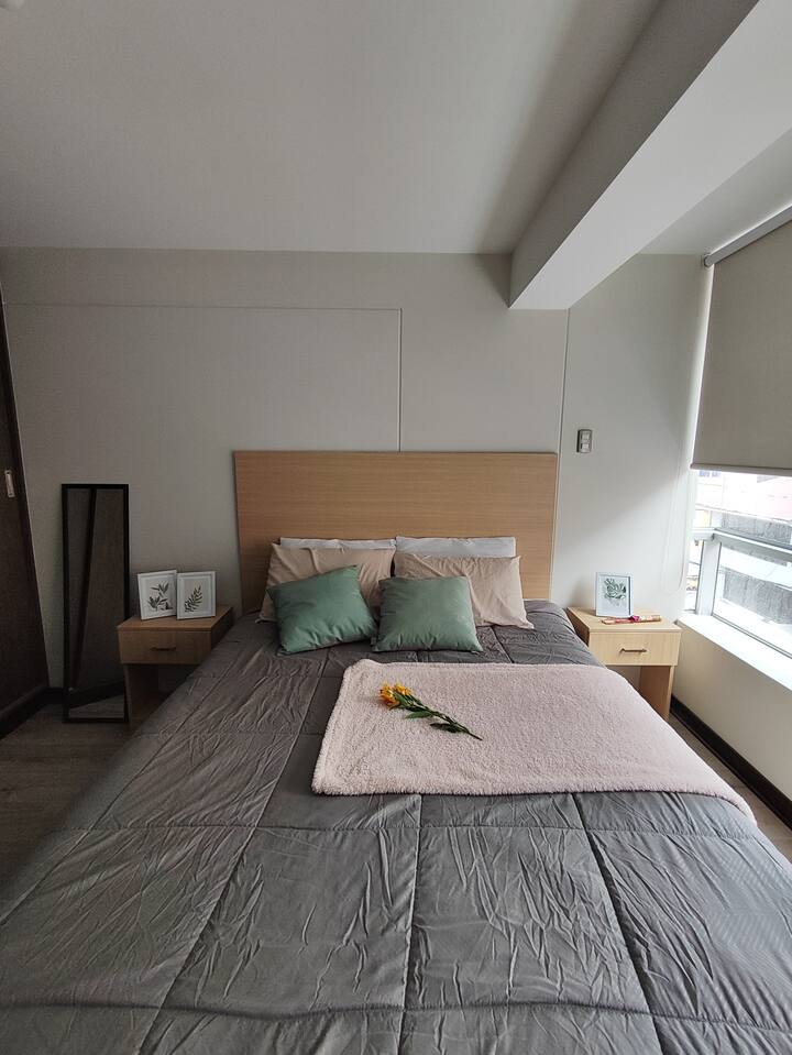Habitación principal con cama Queen (para 2 personas), baño privado, luz natural y un ambiente tranquilo para descansar. Un espacio cómodo y acogedor para recargar energías.