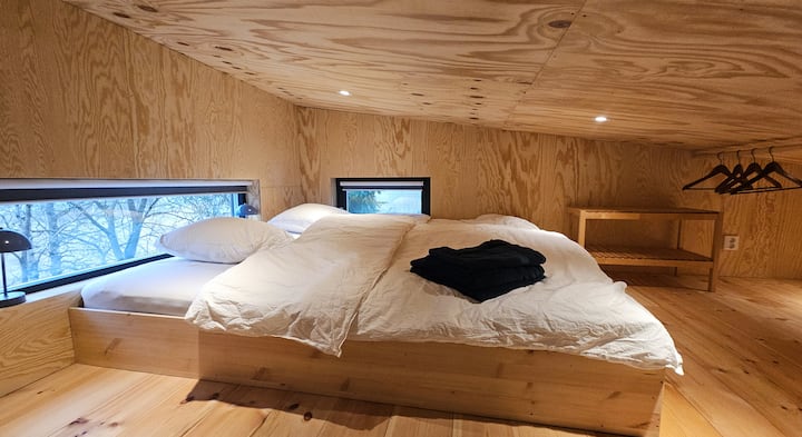 Här har du utsikt över sjön och landsbygden direkt från sängen! Det mindre fönstret kan öppnas och vetter mot öster, vilket ger utsikt mot soluppgången. Om du vill kan du lämna mörkläggningen uppe och låta de första solstrålarna väcka dig på morgonen.