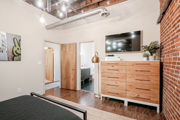 נוף מחדר השינה עם שידה וארון טלוויזיה.