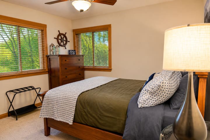 Cozy queen bedroom with warm wood furniture, soft lighting, and comfortable bedding offers a peaceful place to recharge after hiking, skiing, lake days, or exploring North Conway and the White Mountains.