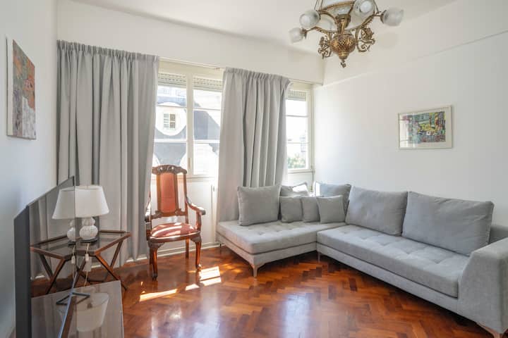 Living amplio y luminoso con cómodos sillones, comedor para varios huéspedes y grandes ventanales que aportan luz y amplitud al espacio.