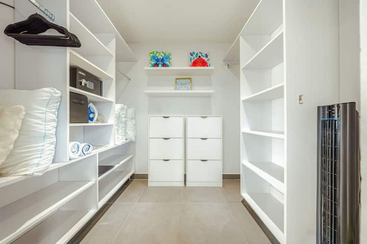 Un espacioso vestidor con muchos estantes y espacio para colgar, perfecto para mantener tus pertenencias organizadas y tu estadía libre de desorden.