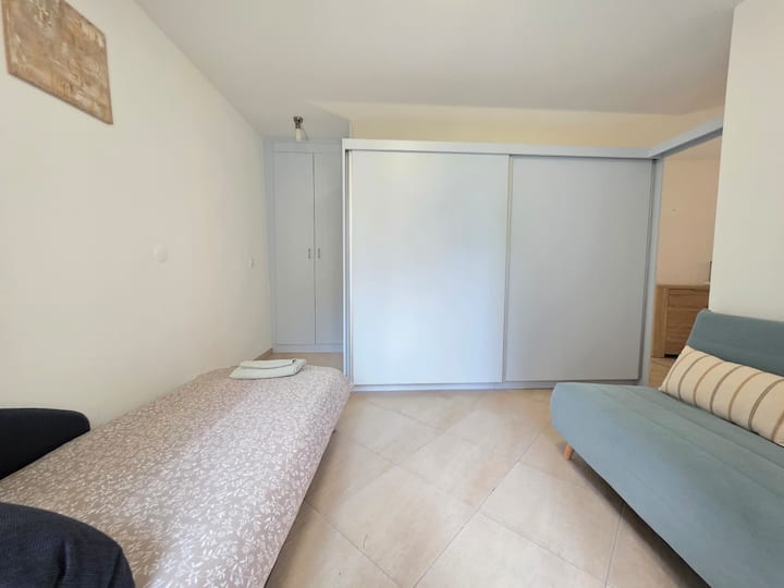 Dhoma e dytë me një krevat tek (90 × 200 cm) dhe një divan-krevat (120 × 190 cm). Divani-krevat ofron rehati bazë dhe është më i përshtatshmi për fëmijët ose adoleshentët. Nuk ka derë apo perde që e ndan këtë dhomë nga dhoma kryesore e gjumit.